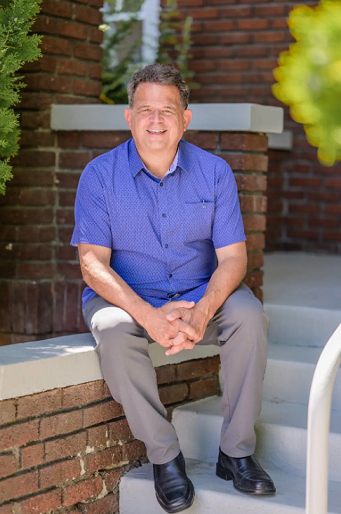 Doug Pitassi in a blue shirt, sitting position
